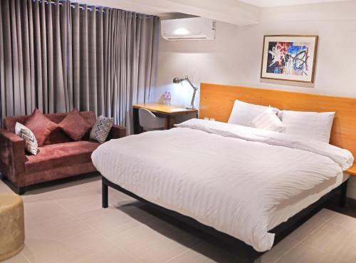 a hotel room with a bed and a couch at The Avenue Hotel in Islamabad