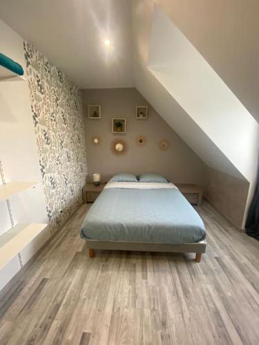 une chambre avec un lit dans un grenier dans l'établissement Grande maison tout confort 24 h - jardin et calme, à Voivres-lès-le-Mans