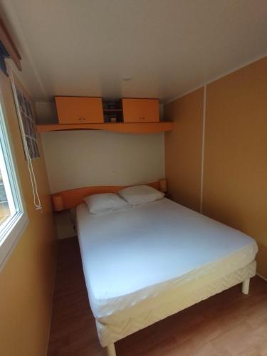 Cette petite chambre comprend un lit blanc et des étagères. dans l'établissement Ongi etorri-cures et vacances, à Cambo-les-Bains