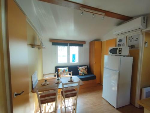 Il comprend une petite cuisine et une salle à manger avec une table et un réfrigérateur. dans l'établissement Ongi etorri-cures et vacances, à Cambo-les-Bains