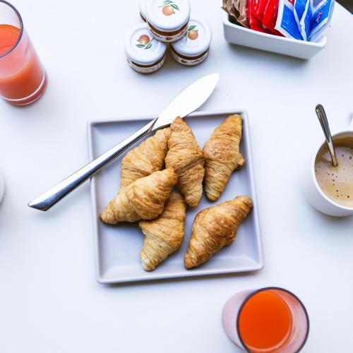 a plate of food with croissants on a table at Flamingo Hotel Malta in St Julian's
