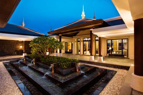 a house with a water feature in front of it at Raffles Hainan Clear Water Bay in Sanya