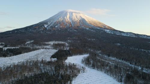 a snow covered mountain in front of a snow covered mountain at Niseko Purr 101 in Kutchan