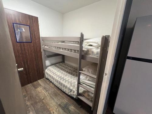 Cette petite chambre comprend des lits superposés et une porte. dans l'établissement Studio - Les Cigales De Mer - Centre Ville -100 m de la plage, au Grau-du-Roi