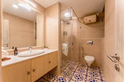 a bathroom with a sink and a toilet at Scenic 1BHK Apartment by tisyastays in Candolim