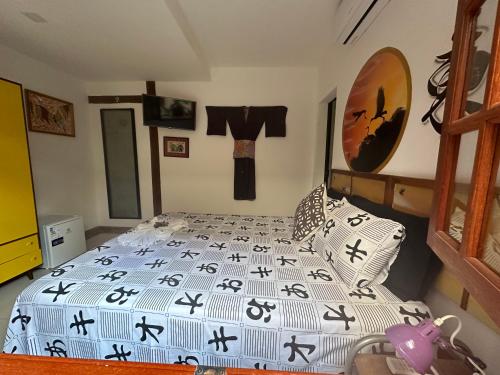 a bedroom with a bed with black and white sheets at Flor de Limão Hotel Boutique in Coroa Vermelha