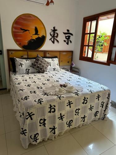 a bedroom with a bed with an asian comforter at Flor de Limão Hotel Boutique in Coroa Vermelha