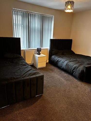 a bedroom with two beds and a couch and a window at WoolPack in Huddersfield