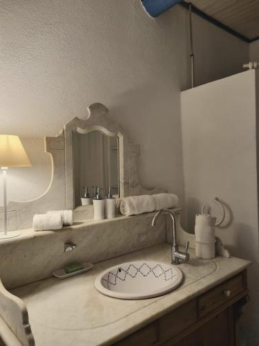 une salle de bain avec un lavabo et un miroir dans l'établissement Maison Chêne Vert, à Sanilhac-et-Sagriès