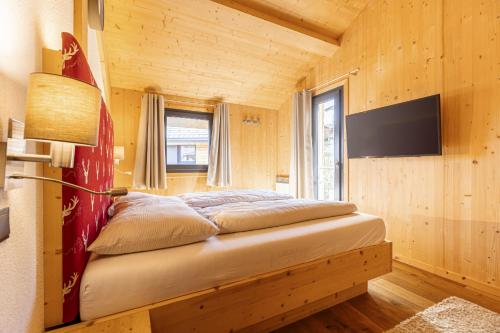 a bedroom with a bed in a wooden room at Alpenchalets Reiteralm by ALPS RESORTS in Schladming