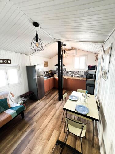 un salon avec une table et une cuisine dans l'établissement Maisonnette de pêcheur chauffée et climatisée, à Port-la-Nouvelle