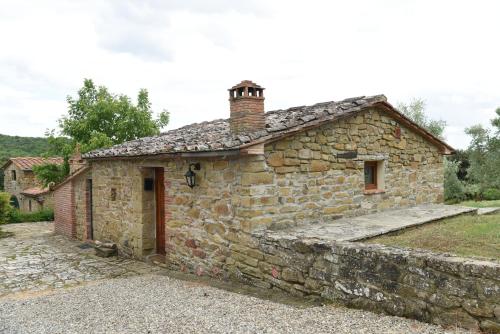 an old stone house with a brick building at Agriturismo I Poggilunghi in Civitella in Val di Chiana