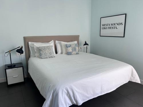 a bedroom with a large bed with white sheets and pillows at Fuerte Confort in La Oliva
