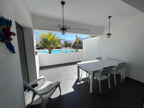 a dining room with a table and chairs and a pool at Fuerte Confort in La Oliva