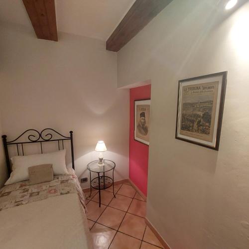 a bedroom with a bed and a table with a lamp at Dimora Garibaldina in Mentana