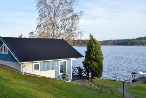a house on a hill next to a lake at Sjöstuga/gästhus i skärgården. in Åkersberga