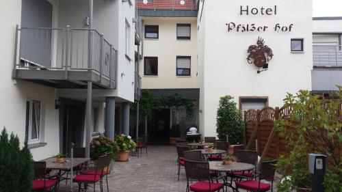 a patio with tables and chairs in front of a hotel at Hotel-Restaurant Pfälzer Hof in Edenkoben