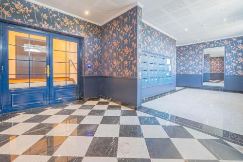 an empty room with blue walls and a checkered floor at Disneyland-Paris 5 personnes, Wifi, Parking in Serris