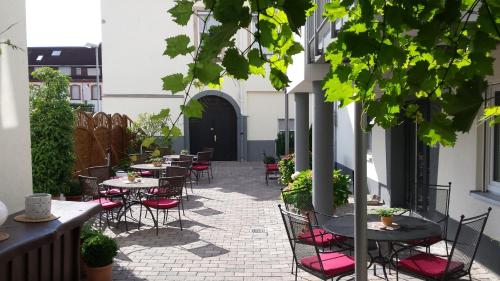a patio with tables and chairs on a building at Hotel-Restaurant Pfälzer Hof in Edenkoben