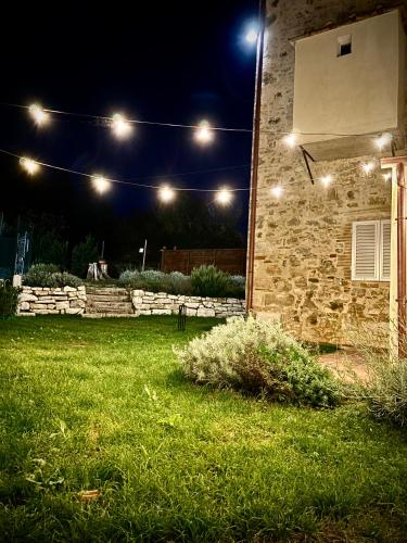 a yard at night with lights on a house at Birillo 1824 in Poggibonsi