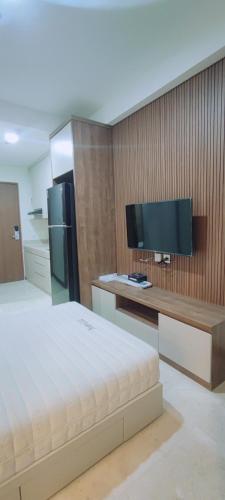 a bedroom with a bed and a desk with a tv at Smart Studio - BResidences ICE BSD in Cilandak