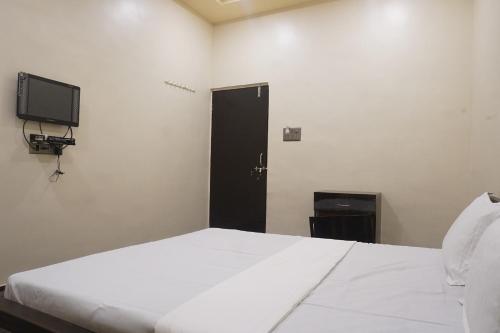 a bedroom with a white bed and a black door at Yashraj Resorts in Pune