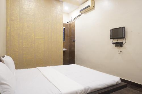 a small room with a bed and a tv on the wall at Yashraj Resorts in Pune