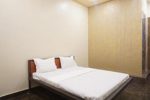 a bed with white sheets and pillows in a room at Yashraj Resorts in Pune