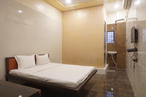 a small room with a bed and a shower at Yashraj Resorts in Pune