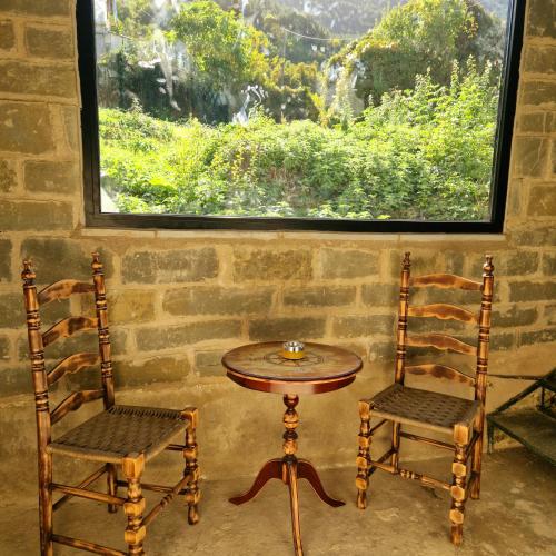 a table and two chairs in a room with a window at Villa Vakalis in Ioannina