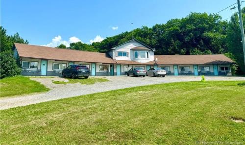 a house with two cars parked in front of it at Lakeview Motel Jemseg in Jemseg