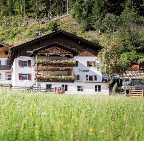 a building with a balcony with flowers on it at Oberwirt in Selva dei Molini
