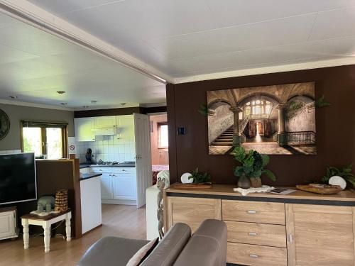 a living room with a couch and a kitchen at Veluwe Park Reewold Chalet Infinity in Putten