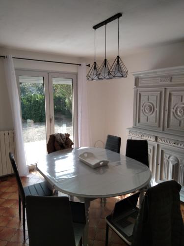- une table à manger avec des chaises et un ordinateur portable dans l'établissement villa au calme 6 couchages, à Trèbes