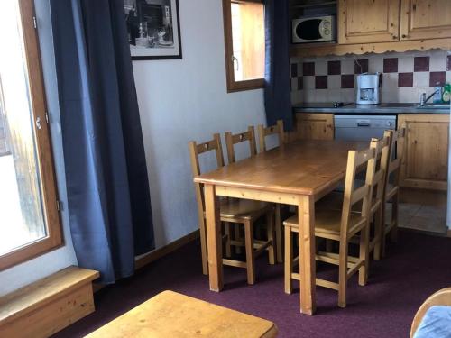 - une table et des chaises en bois dans la cuisine dans l'établissement Appartement 6 pers avec balcon, WIFI, animaux et parking - FR-1-636-55, à Orcières