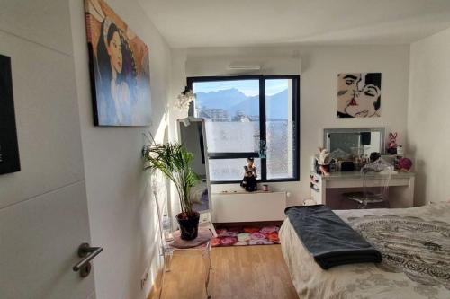 une chambre avec un lit et une grande fenêtre dans l'établissement Nid zen, décoré, avec ascenseur, élégant & calme, à Annecy