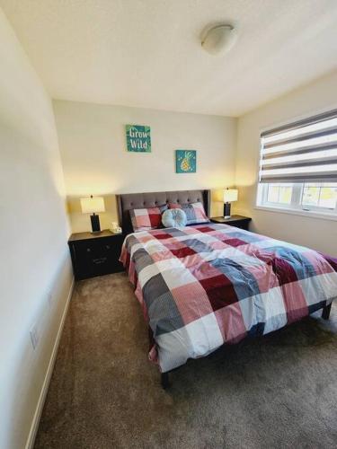 a bedroom with a bed with a plaid blanket at Majestic Elegance-15 mins-Niagara Falls & 10 mins-Brock University in Thorold