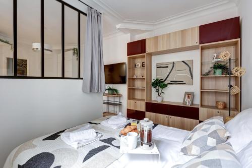 - une chambre avec un lit et une table dans l'établissement Élégante Suite Haussmannienne au Prestige Parisien, à Paris