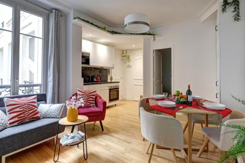 un salon avec un canapé et une salle à manger dans l'établissement Élégante Suite Haussmannienne au Prestige Parisien, à Paris