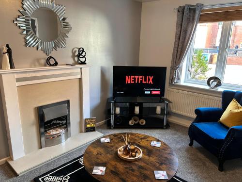 a living room with a fireplace and a tv at Dovefield House - Modern 3 Bed Home from Home - Alton Towers, Uttoxeter Races in Uttoxeter