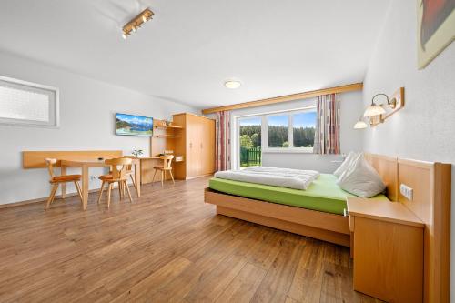 a bedroom with a bed and a table and chairs at Aparthotel Sunrise in Ramsau am Dachstein