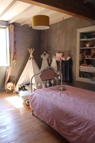 - une chambre avec un lit dans une pièce dotée de portants dans l'établissement Grande maison familiale 4 chambres, à Ganac