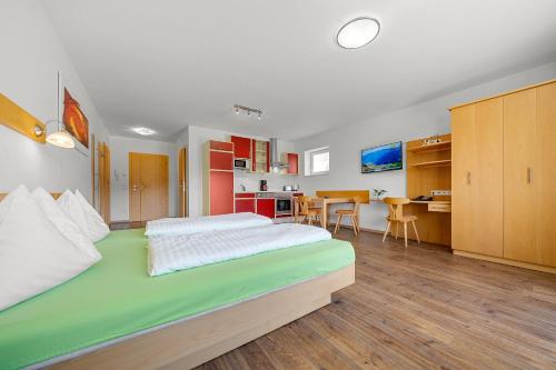 a bedroom with a large bed and a kitchen at Aparthotel Sunrise in Ramsau am Dachstein
