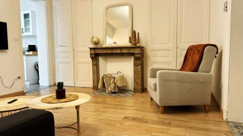 a living room with a chair and a mirror at Appartement Villa Les Lilas in Dunkerque