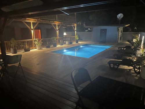 a large swimming pool in a room with chairs at Logement avec piscine a 50 metre de la mer in Cayenne