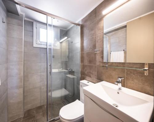 a bathroom with a toilet and a sink and a shower at Santa Marina House in Lefkada