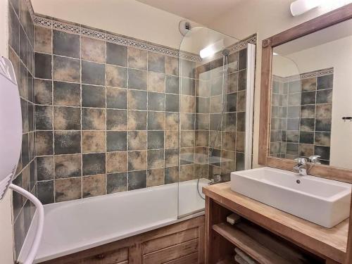 une salle de bain avec un lavabo et une baignoire dans l'établissement Superbe appartement avec piscine au centre St lary village, à Saint-Lary-Soulan