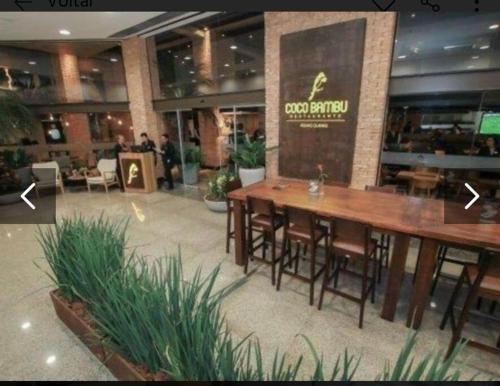 a restaurant with tables and chairs in a building at Apartamento dentro do shopping águas claras, Lindo in Taguatinga