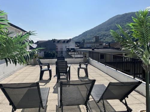 eine Terrasse mit Stühlen und einem Tisch auf einem Balkon in der Unterkunft Appartement le Soleil 140 m2 climatisé parking privé proche Sanctuaires in Lourdes