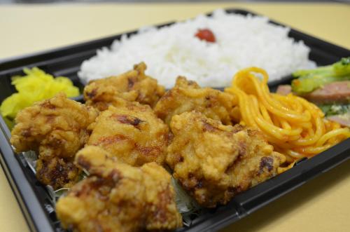 a black container of food with rice and noodles at Guest House Isa in Motobu